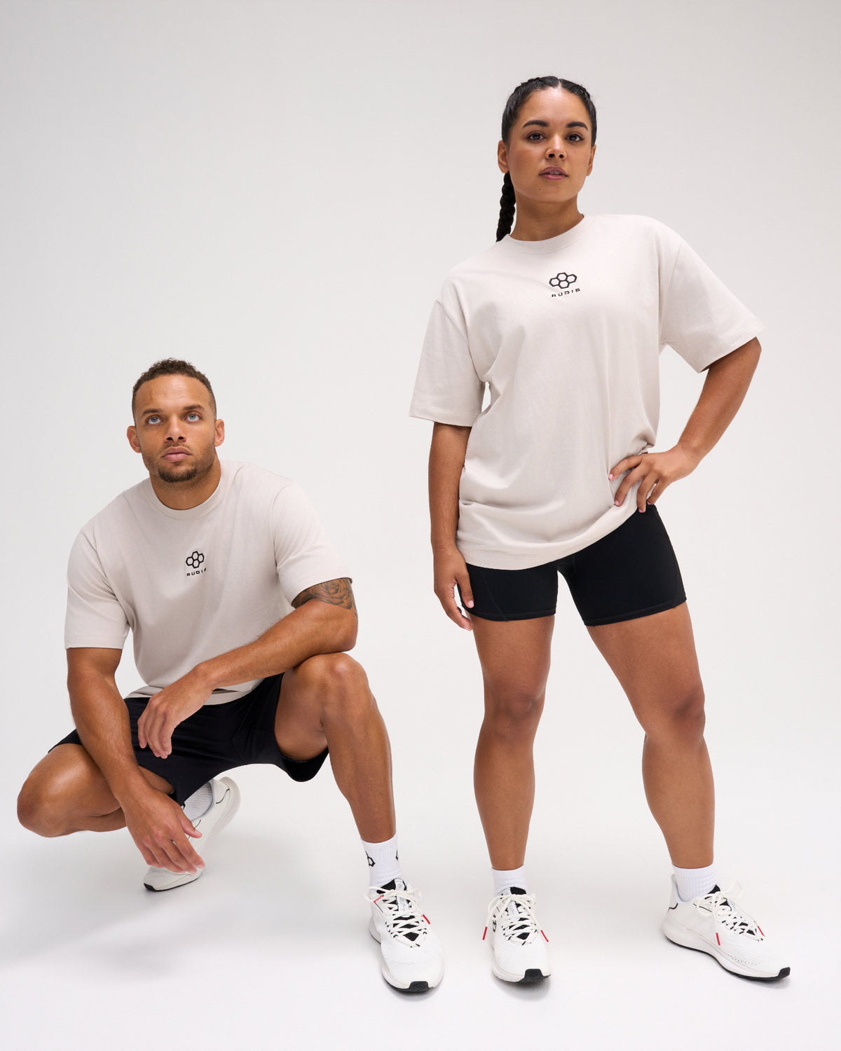 Two models wearing the RUDIS Hex Classic Cotton T-Shirt in Bone, featuring black embroidered Hex chest logos, short sleeves and relaxed everyday styling.
