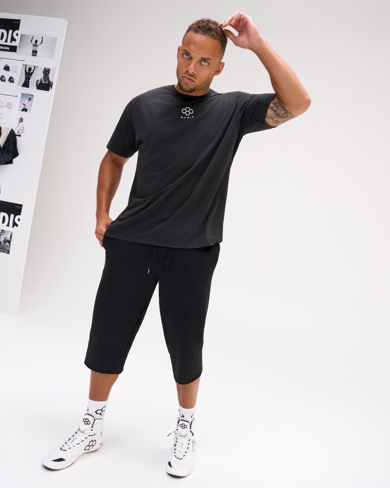 Full-body view of a male model wearing the RUDIS Hex Classic Cotton T-Shirt in Washed Black, showcasing the white Hex logo and classic crewneck silhouette.