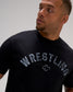 Close-up of the RUDIS Wrestling Classic Cotton T-Shirt in Black, highlighting distressed gray Wrestling lettering and the RUDIS Hex logo.