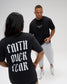 Male and female models wearing the RUDIS Faith Over Fear Classic Cotton T-Shirt in Washed Black, showing white chest graphics and bold back lettering.