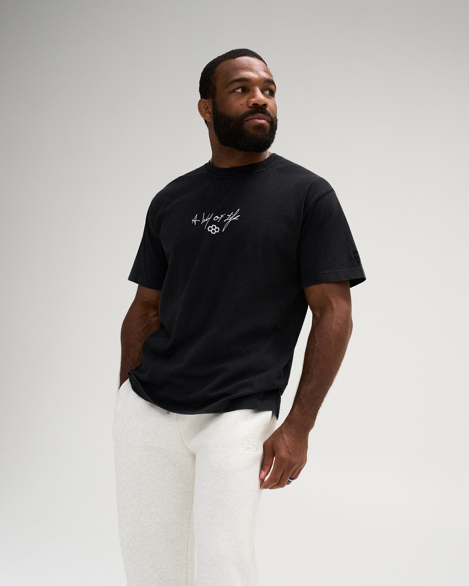 Male model wearing the RUDIS Faith Over Fear Classic Cotton T-Shirt in Washed Black, featuring a white A Way of Life chest graphic and RUDIS Hex logo.