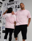 Male and female models wearing the RUDIS Wrestling Back Relaxed Cotton T-Shirt in Washed Pink, showcasing the white RUDIS front logo and oversized WRESTLING back graphic.