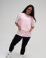 Female model wearing the RUDIS Wrestling Back Relaxed Cotton T-Shirt in Washed Pink, featuring a small white RUDIS chest logo, crew neckline, and relaxed fit.