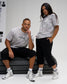 Male and female models wearing RUDIS Relaxed Cotton T-Shirts in a light gray tree camouflage print with gray RUDIS chest logos.