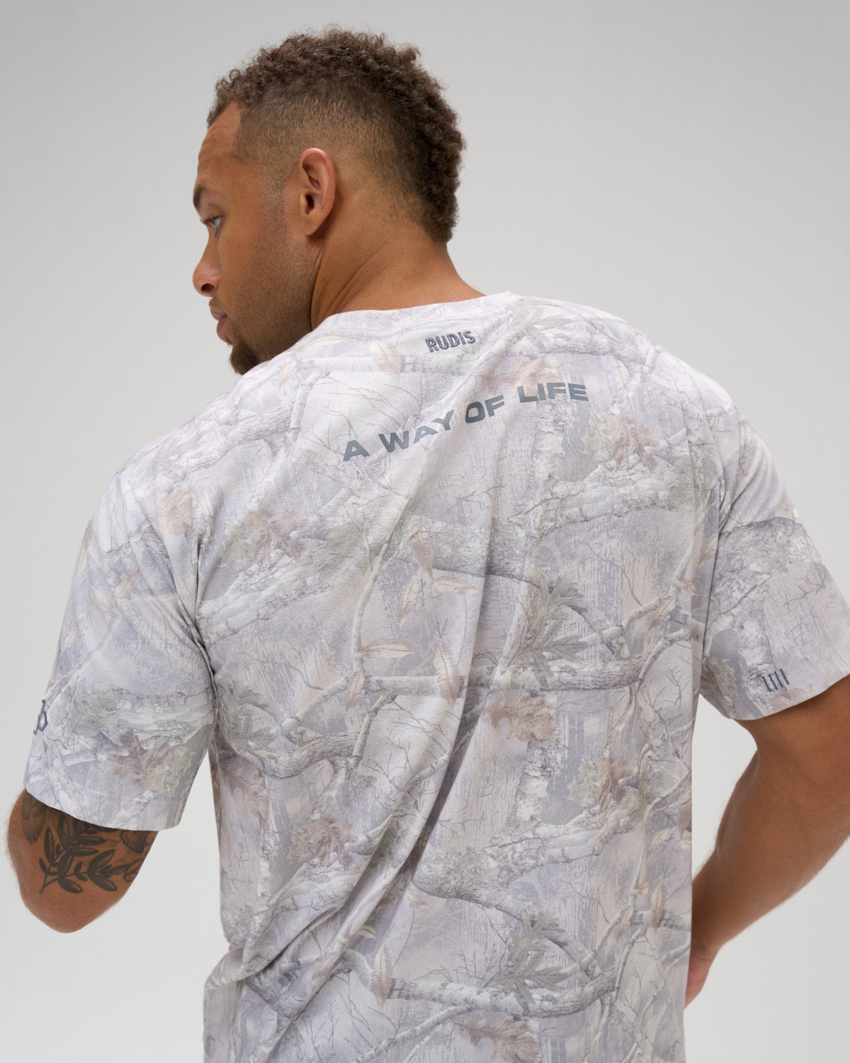 Back view of male model wearing the RUDIS Relaxed Cotton T-Shirt in tree camo with A WAY OF LIFE lettering across the upper back.