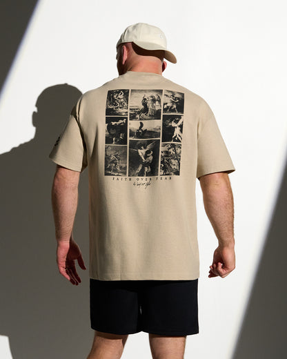 Man wearing a beige t-shirt with graphic design on the back, standing against a white background.