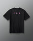 A black short-sleeve crewneck t-shirt with three small pink graphic icons printed across the chest, displayed against a neutral gray background.