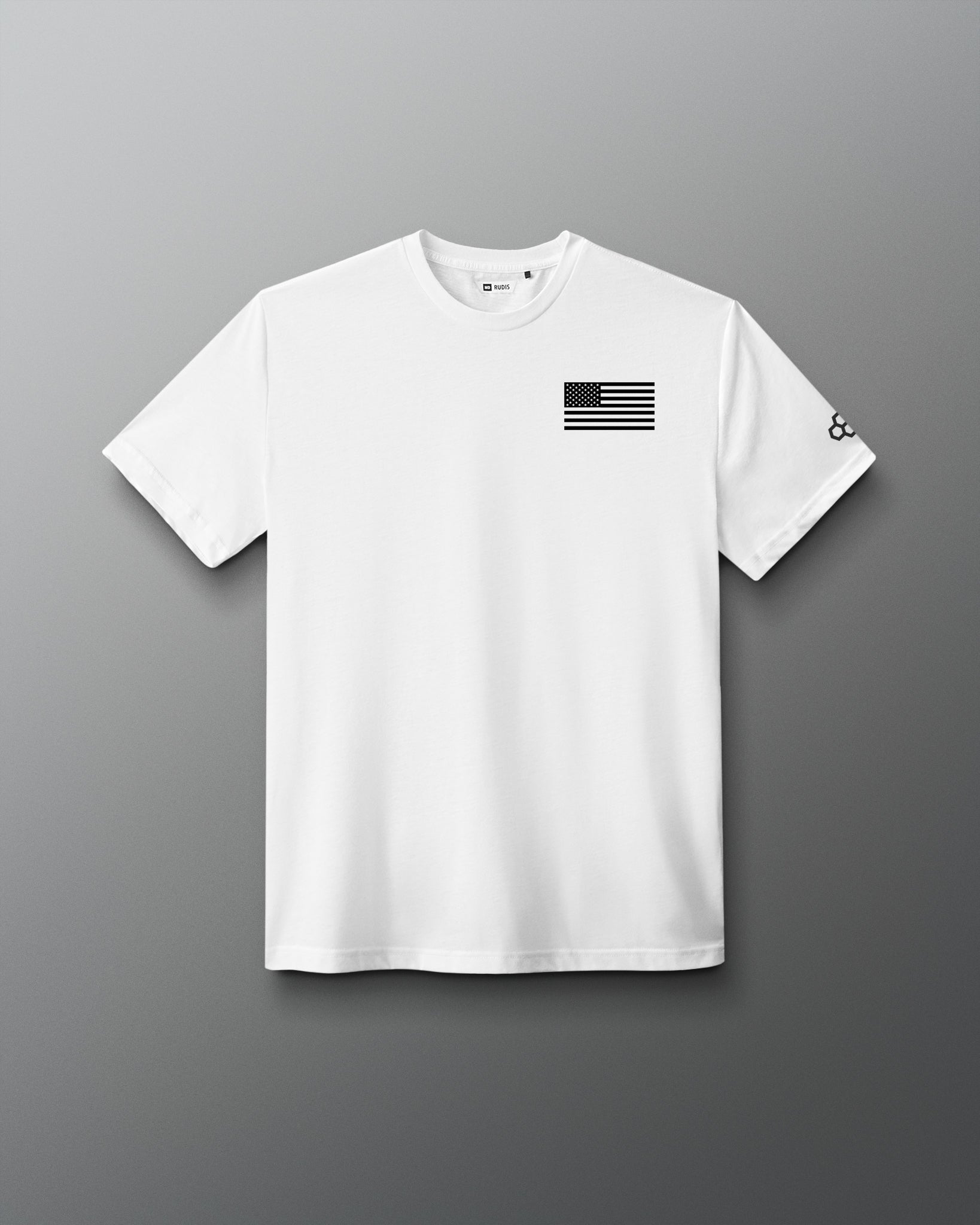 White RUDIS Core Flag Elite Super Soft T-Shirt shown from the front, featuring a black American flag graphic on the chest and contrasting RUDIS mark on the sleeve.