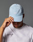 Person wearing a light blue cap and white t-shirt with text on a gray background