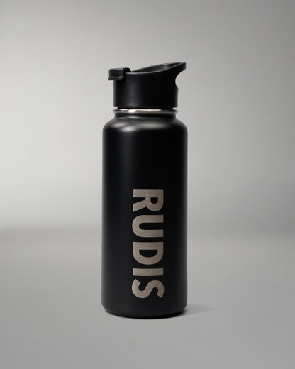 A matte black insulated water bottle with a flip-top lid, featuring the brand name 'RUDIS' printed vertically in a light beige sans-serif font on the front, set against a neutral gray studio background.