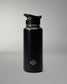 A matte black insulated water bottle with a matching black flip-top lid, featuring a small silver geometric logo near the bottom, set against a neutral gray studio background.