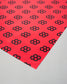 Red paper with black geometric pattern on a gray background