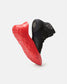 A modern athletic shoe featuring a distinctive design with a black upper and a striking red sole showcasing advanced grip technology and stylish aesthetics