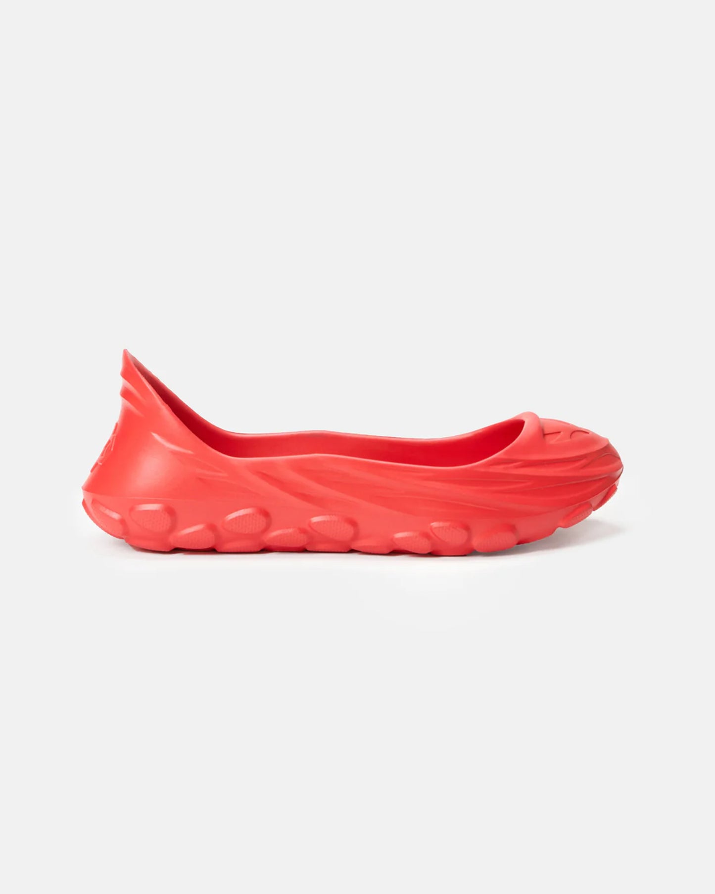 This image showcases a vibrant red slip-on shoe with a sleek design and a textured rounded sole