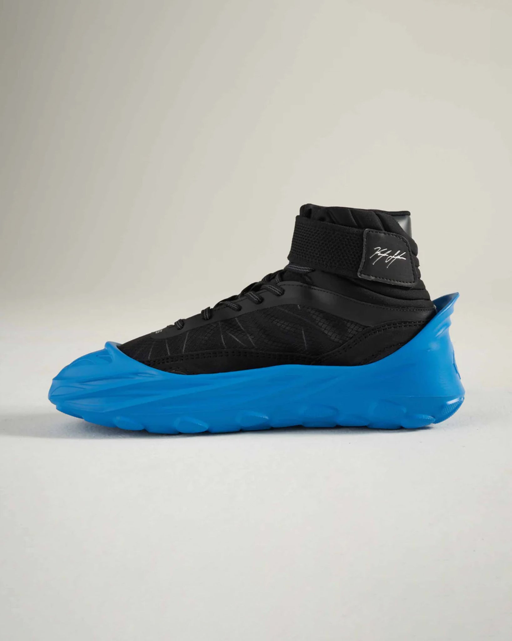 A modern black and blue athletic shoe with a unique design featuring a high-top silhouette and distinctive sole