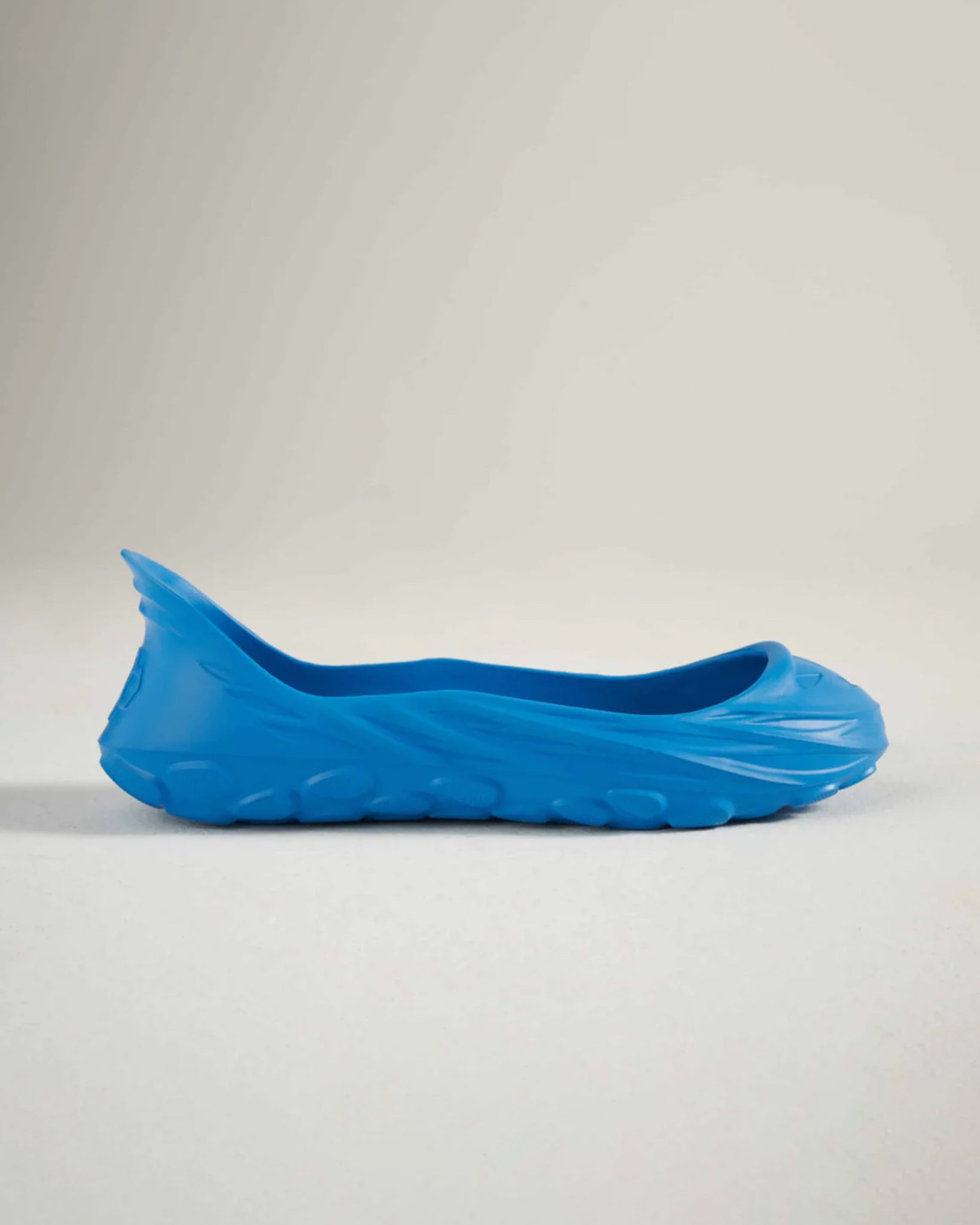 A vibrant blue shoe showcasing a unique fluid design with a textured sole suitable for casual wear
