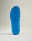 The image displays a vibrant blue shoe sole featuring a textured grip pattern designed for optimal traction on various surfaces