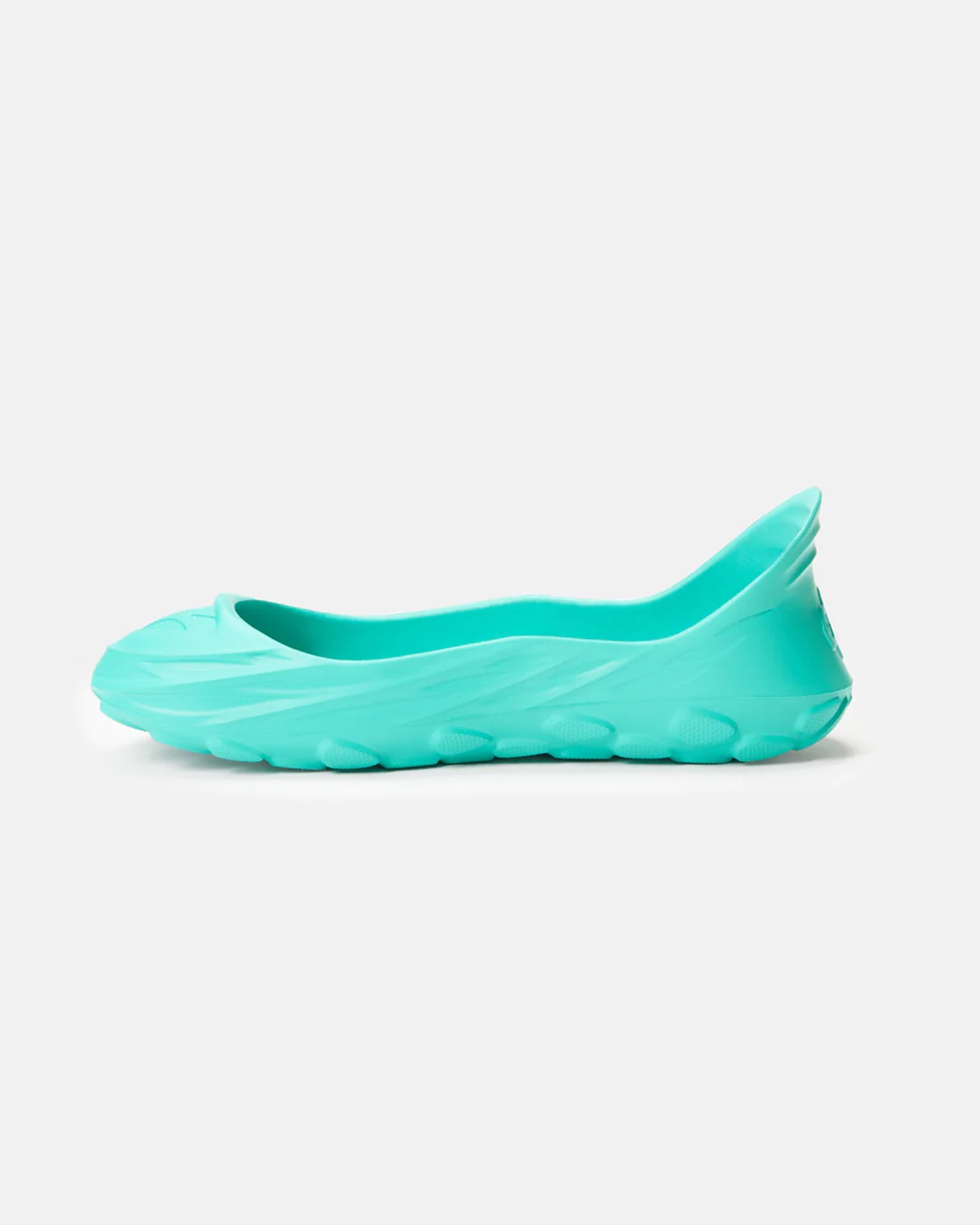 A side view of a vibrant turquoise womens slip-on shoe with a sleek modern design and textured sole