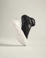 A pair of modern athletic shoes in black and white with dynamic design elements showcasing their unique textured soles and sleek silhouette