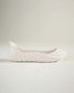 A sleek white slip-on shoe featuring a modern design and textured sole perfect for casual wear and comfort