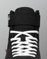 Black wrestling shoe with white laces on a gray background
