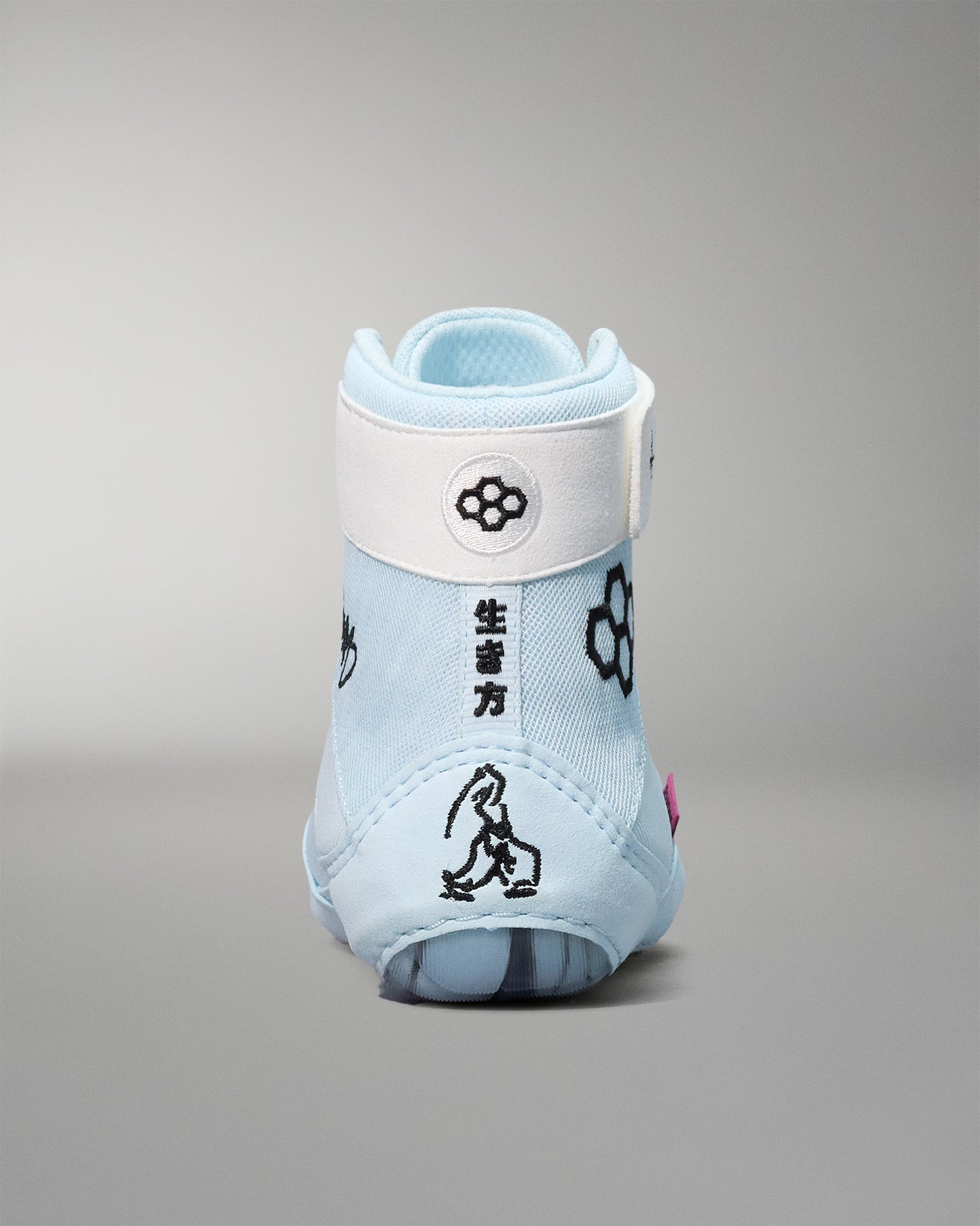 Light blue wrestling shoe with white sole on a gray background