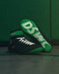 Black and green wrestling shoes with visible branding on a green background