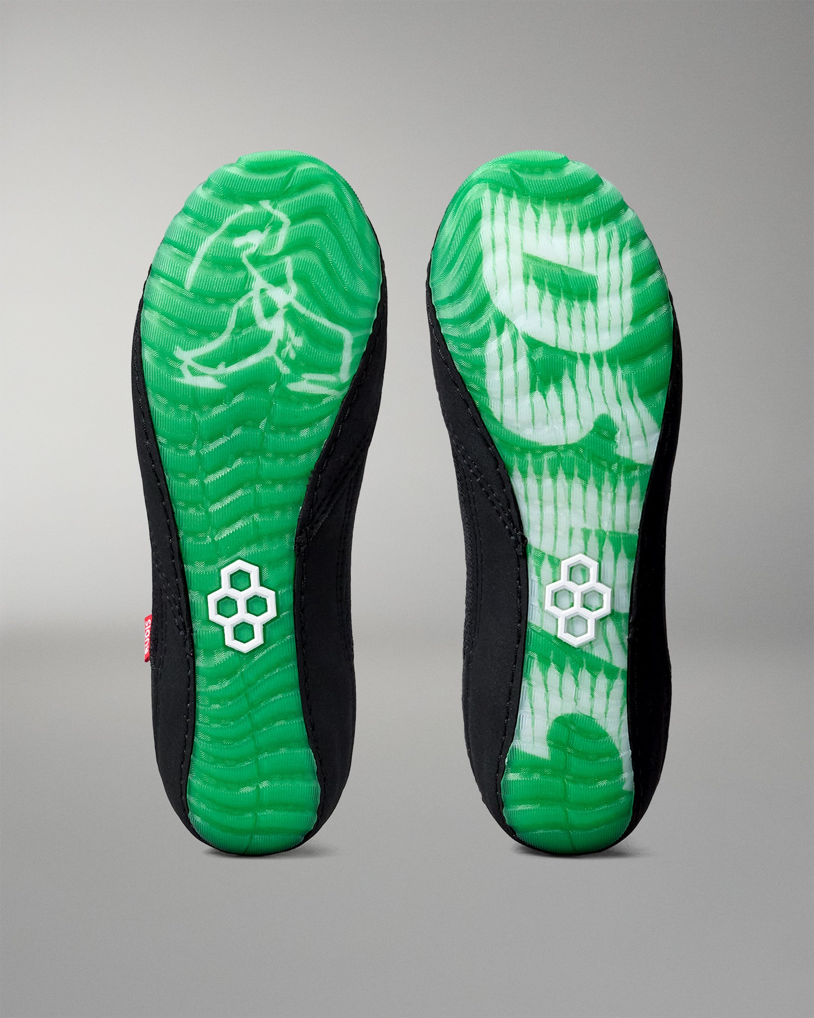 Green and black wrestling shoe insole with a brand logo on a gray background