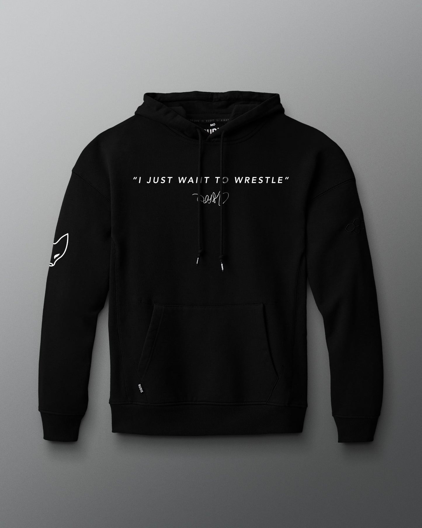 Front view of a black hoodie featuring the phrase “I JUST WANT TO WRESTLE” in white block letters across the chest, with a signature printed below. Includes a front kangaroo pocket and subtle graphics on both sleeves.
