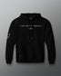 Front view of a black hoodie featuring the phrase “I JUST WANT TO WRESTLE” in white block letters across the chest, with a signature printed below. Includes a front kangaroo pocket and subtle graphics on both sleeves.