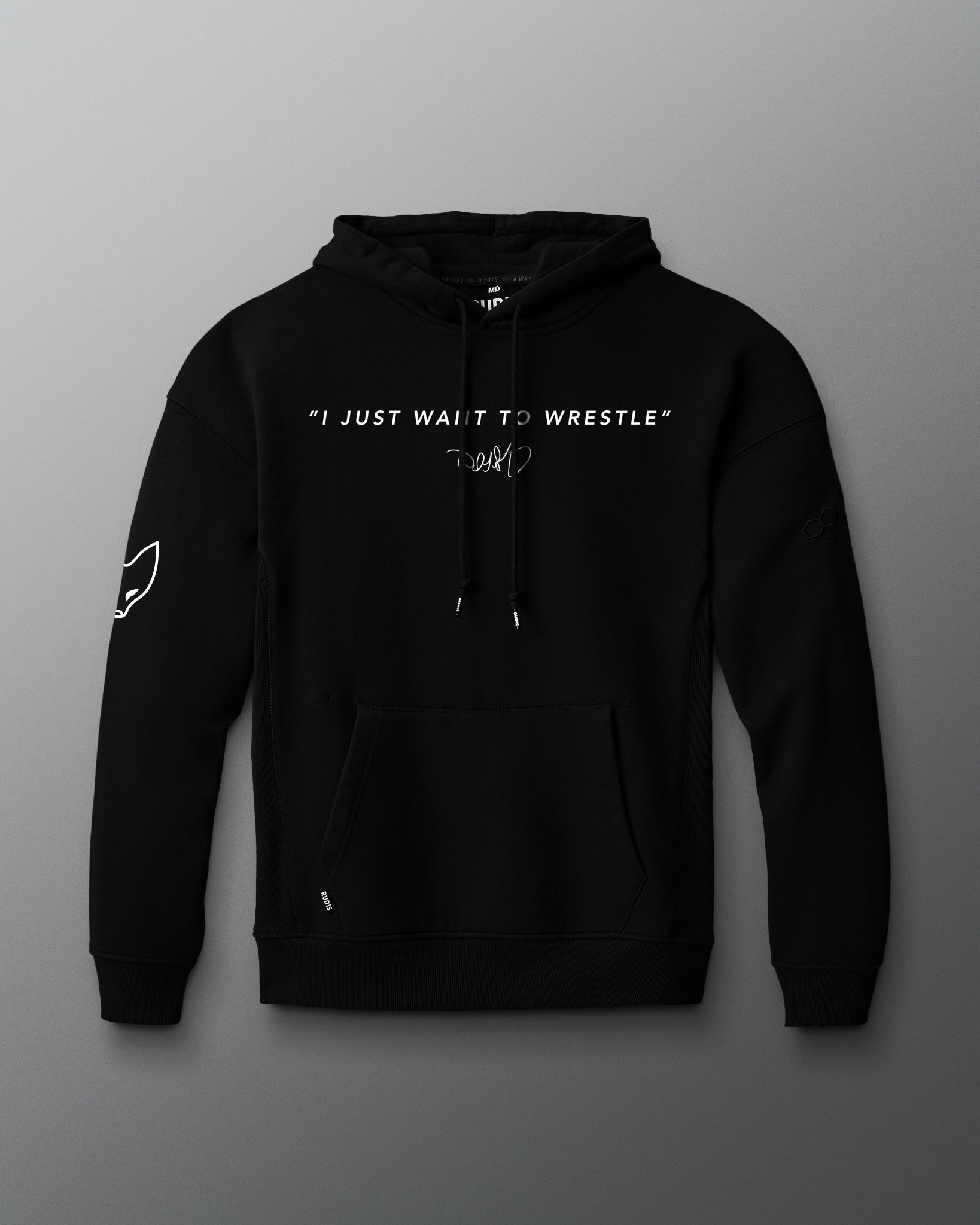 Front view of a black hoodie featuring the phrase “I JUST WANT TO WRESTLE” in white block letters across the chest, with a signature printed below. Includes a front kangaroo pocket and subtle graphics on both sleeves.