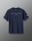 Front view of a navy RUDIS t-shirt featuring the quote “I JUST WANT TO WRESTLE” in white capital letters across the chest, with a signature-style graphic underneath. The left sleeve displays a stylized fox head icon, and the right sleeve features the RUDIS hex logo.