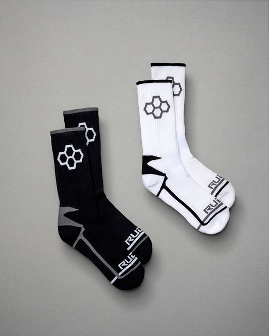 A pair of athletic socks in black and white featuring modern designs with hexagonal patterns and contrasting accents