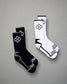 A pair of athletic socks in black and white featuring modern designs with hexagonal patterns and contrasting accents