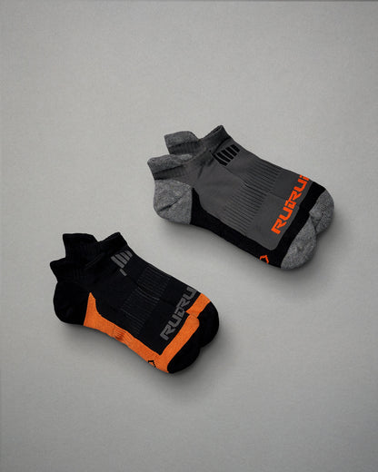This image features two pairs of athletic socks one in black with orange accents and the other in gray with black details both designed for comfort and performance
