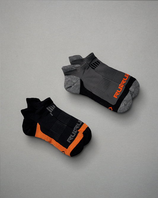 This image features two pairs of athletic socks one in black with orange accents and the other in gray with black details both designed for comfort and performance