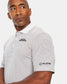 A man in a striped polo shirt featuring the Sports Illustrated logo looks thoughtfully to the side with a slight smile