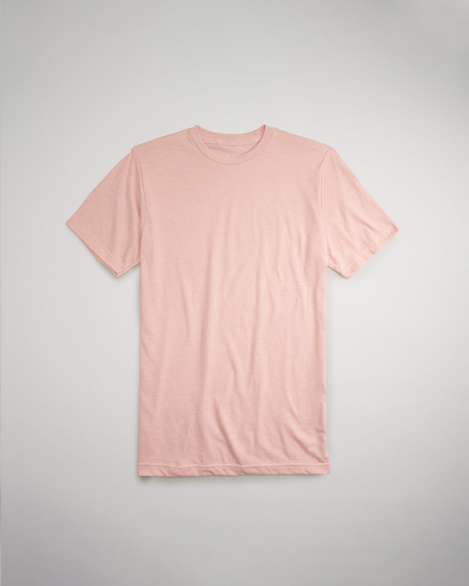 A soft pink short-sleeve t-shirt is displayed flat against a light gray background