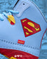 Superman logo on a light blue wrestling shoe with red and yellow accents, featuring the brand 'Rudis'.