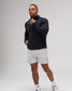 Model wearing the black RUDIS Victory 1/4 Zip performance pullover with light gray athletic shorts and white training shoes.