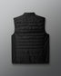 Black puffer vest on a light gray background