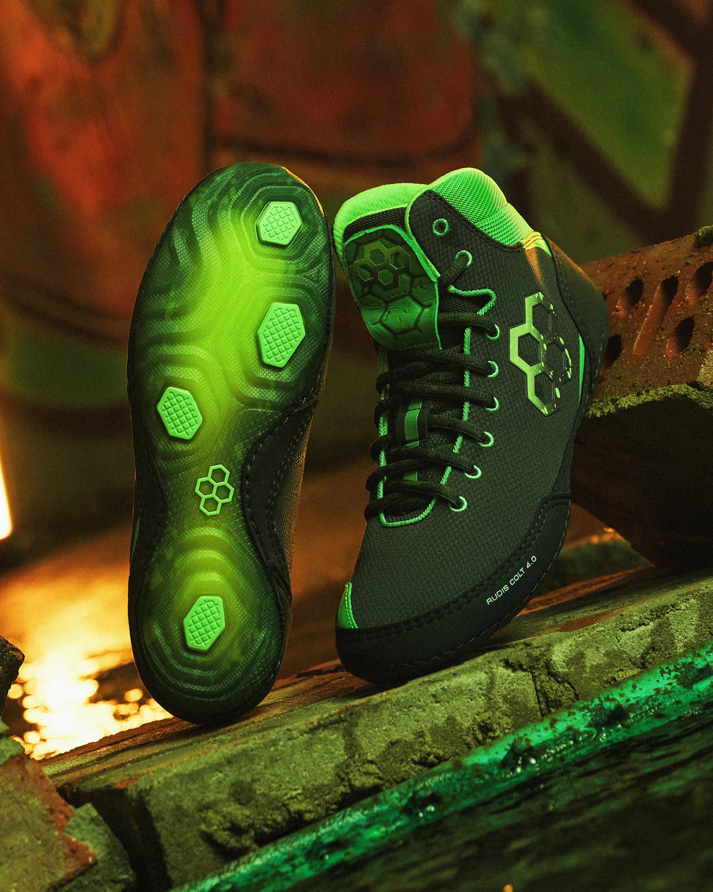 Black and green Wrestling shoes on a rustic wooden surface with a warm glow.