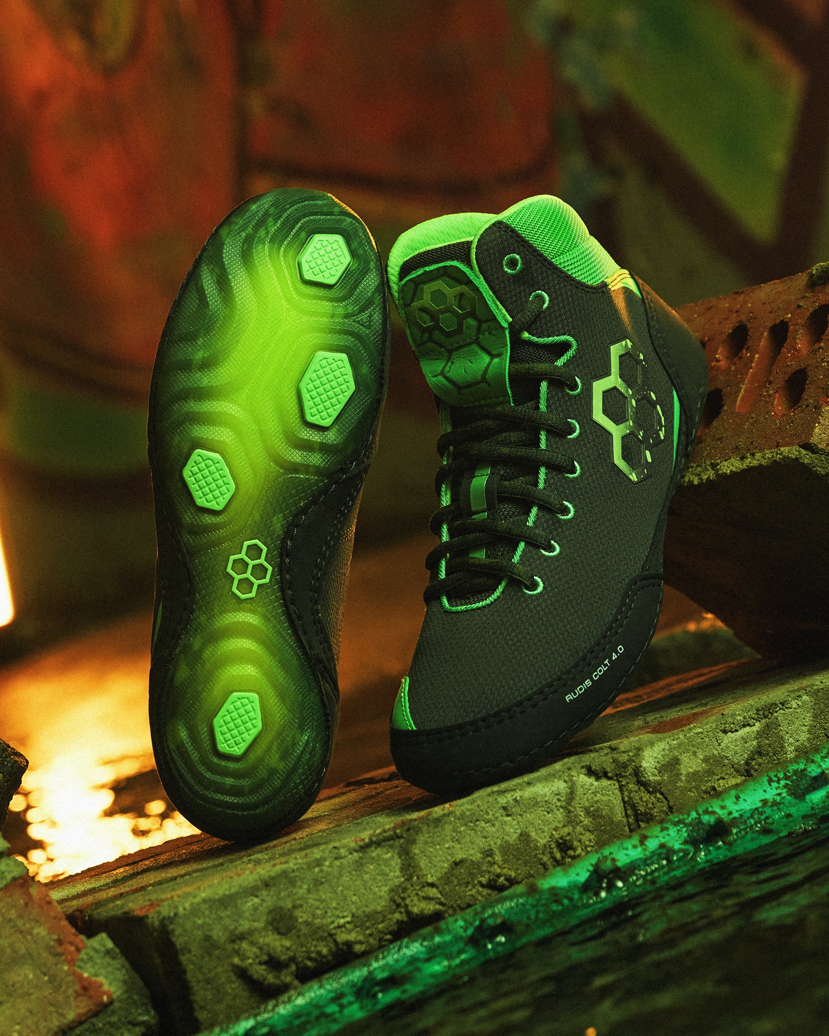 Black and green Wrestling shoes on a rustic wooden surface with a warm glow.