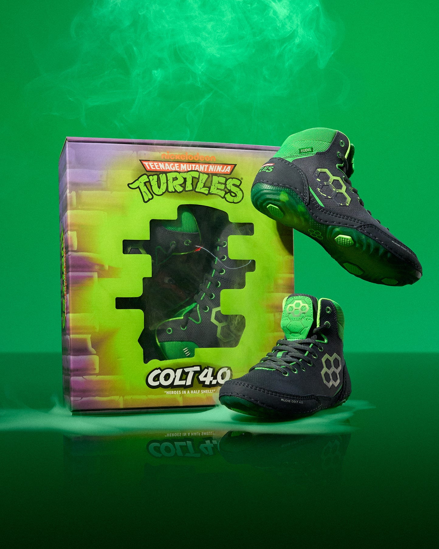 Black and green Wrestling shoes with 'Teenage Mutant Ninja Turtles' branding next to a box on a green background