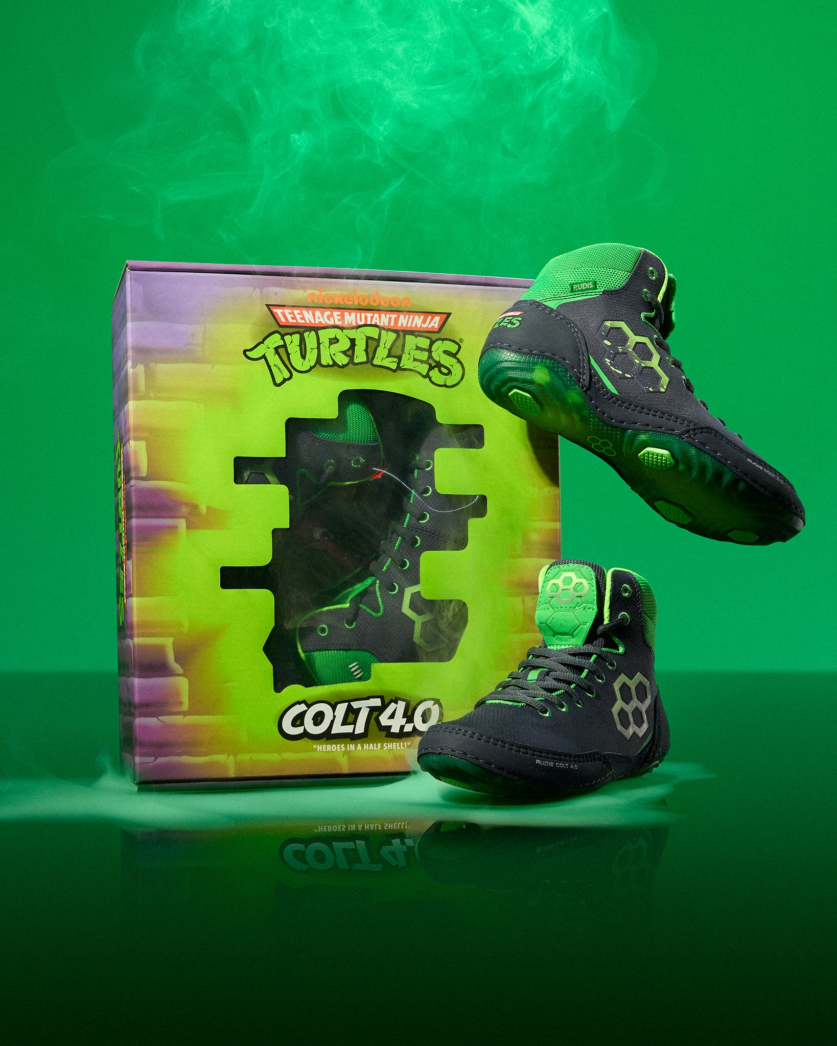 Black and green Wrestling shoes with 'Teenage Mutant Ninja Turtles' branding next to a box on a green background