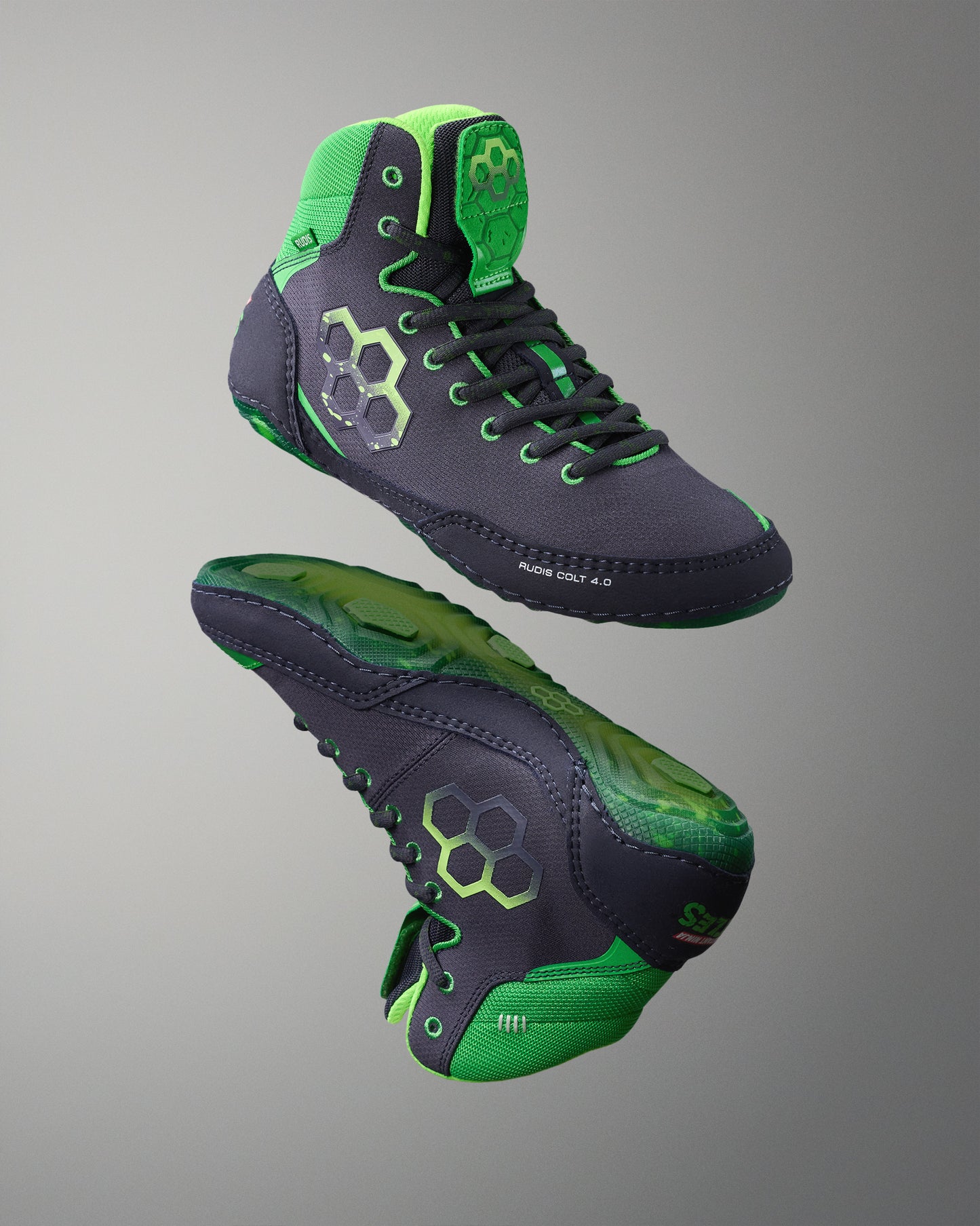 Pair of green and black Wrestling shoes on a gray background