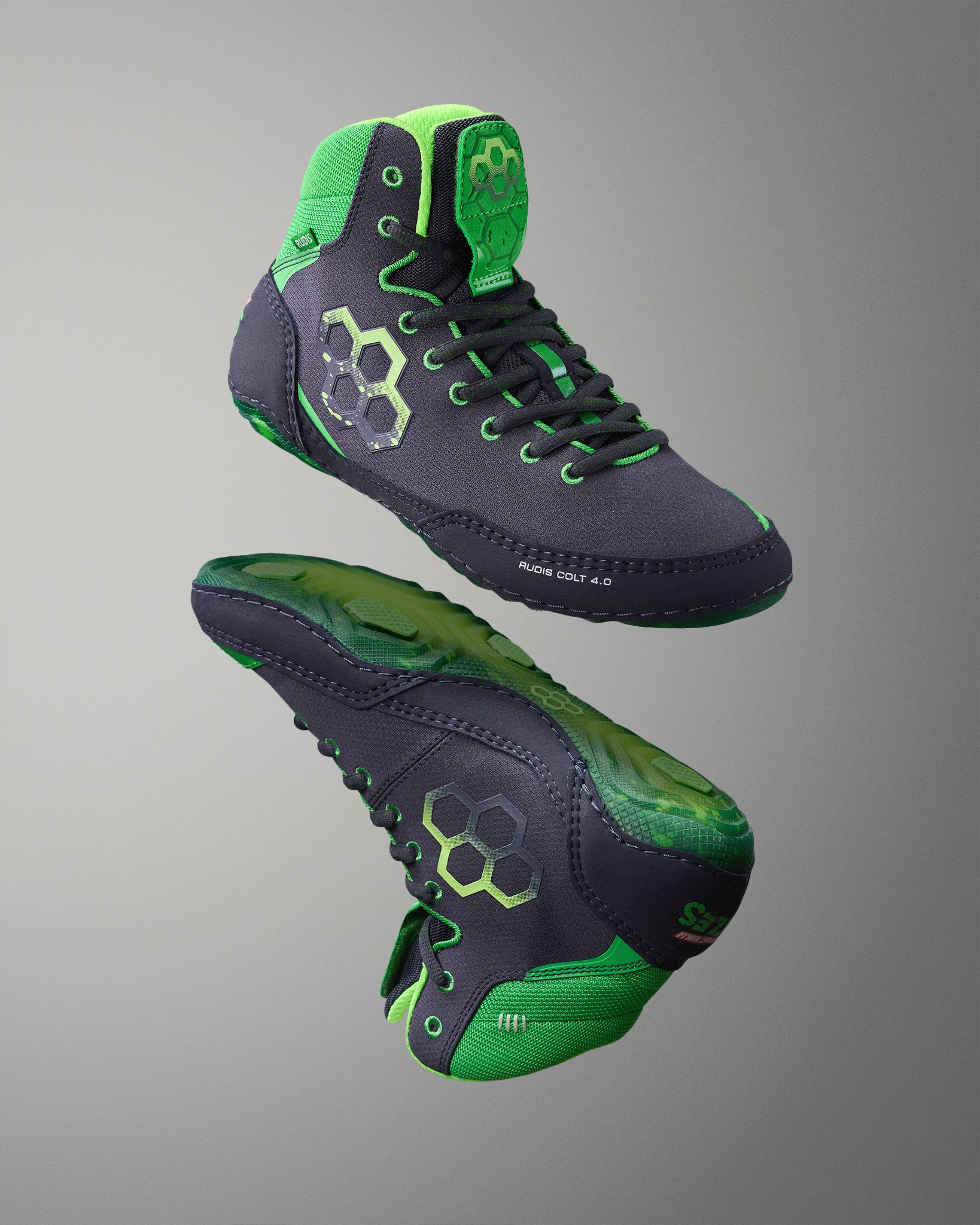 Pair of green and black Wrestling shoes on a gray background