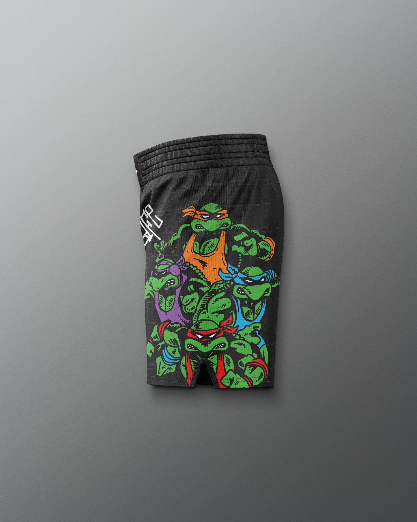 Black shorts with colorful graphic design on a gray background. TMNT. Teenage Mutant Ninja Turtle