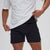 Person wearing a white shirt and black shorts on a light gray background