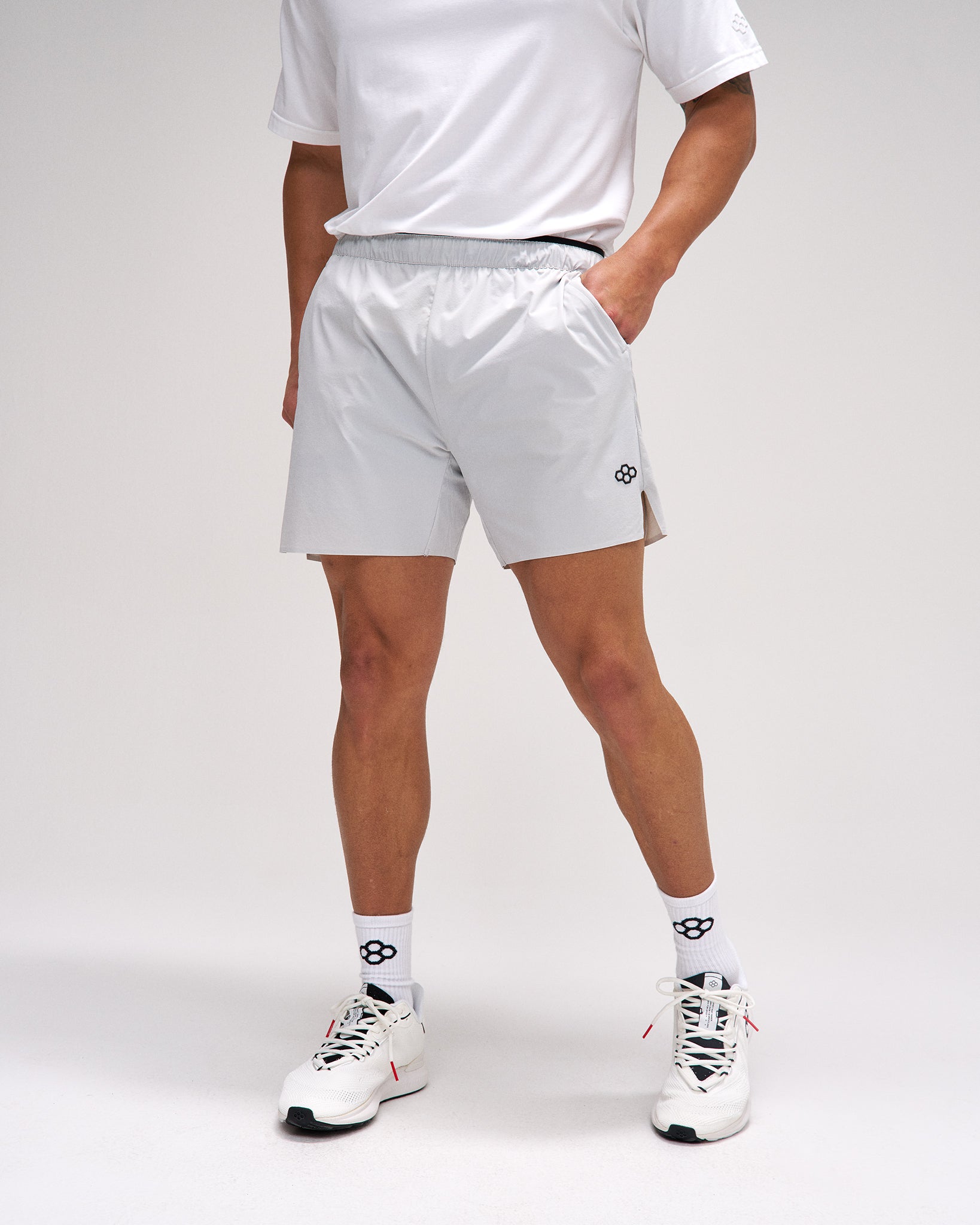 Person wearing light gray shorts with a brand logo on a white background